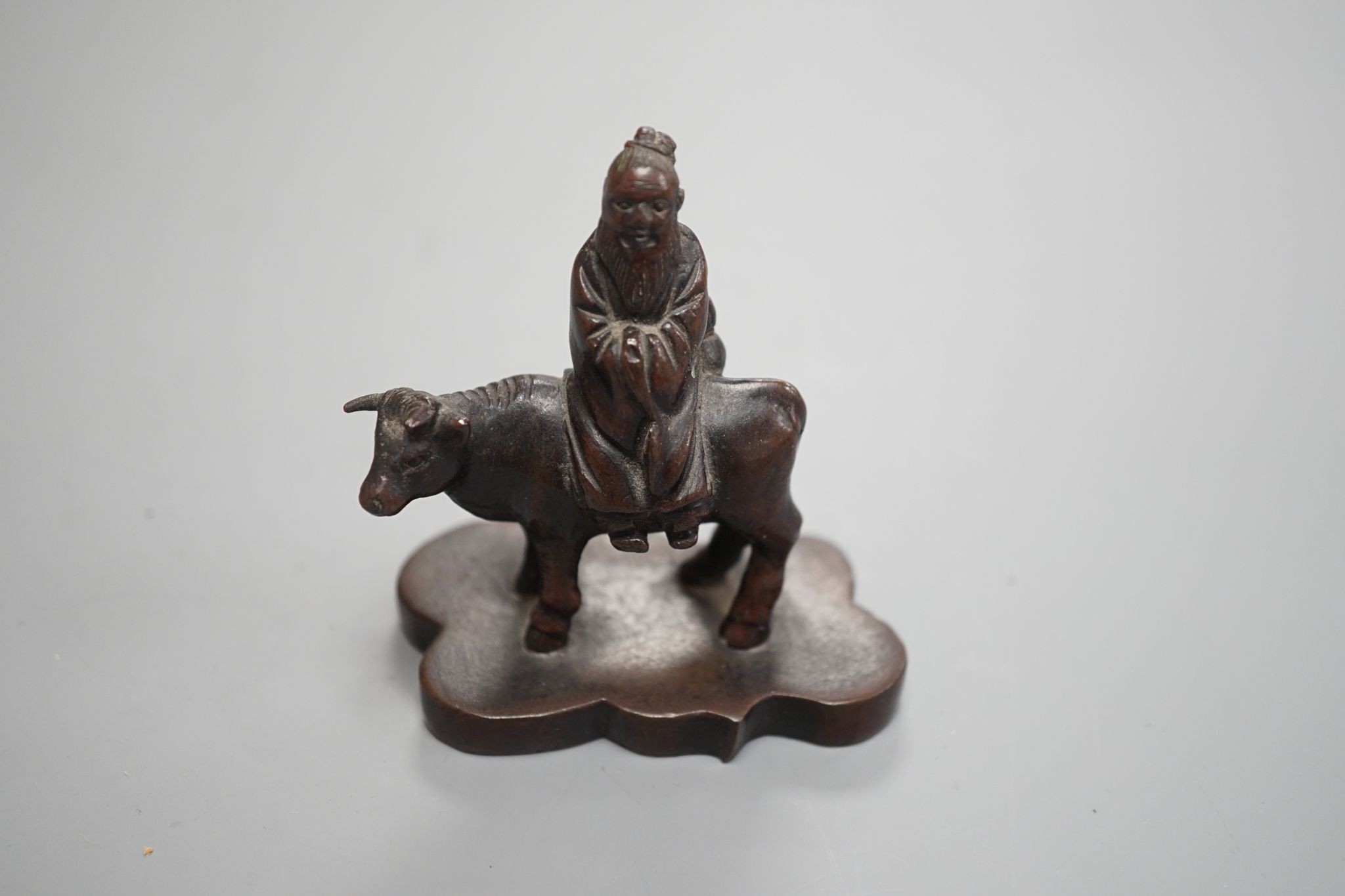 A small Chinese bronze seal of an immortal riding a bull and a Tibetan prayer case 9cm